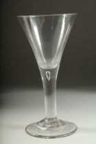 A LARGE PLAIN GEORGIAN WINE GLASS with tapering bowl, tear drop and heavy stand. 8.25ins high.