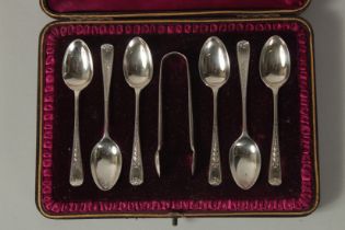 A SET OF SIX VICTORIAN TEA SPOONS AND SUGAR TONGS. London 1888. Cased.