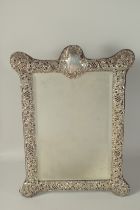 A GOOD LARGE VICTORIAN SILVER REPOUSSE DECORATED EASEL MIRROR, Chester 1901. 20ins x 14ins.