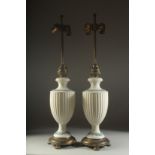 A GOOD PAIR OF WEDGWOOD PORCELAIN LAMPS on circular metal bases. 30ins high overall.
