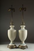 A GOOD PAIR OF WEDGWOOD PORCELAIN LAMPS on circular metal bases. 30ins high overall.