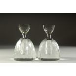A PAIR OF CIRCULAR CUT GLASS DECANTERS AND STOPPERS. 5.5ins high.