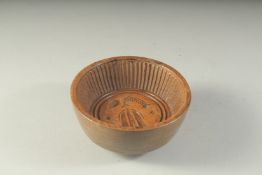 AN EARLY WOODEN CIRCULAR JELLY MOULD. 6ins diameter.