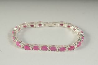 A SILVER RUBY SET LINE BRACELET, boxed.