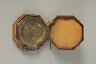 A GEORGIAN OCTAGONAL BRASS TRAVELLING COMPASS with silvered dial. Made in Paris. 3.75ins in a