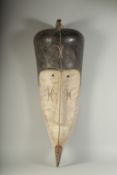 A LARGE CARVED AND PAINTED TRIBAL MASK. 29ins long.