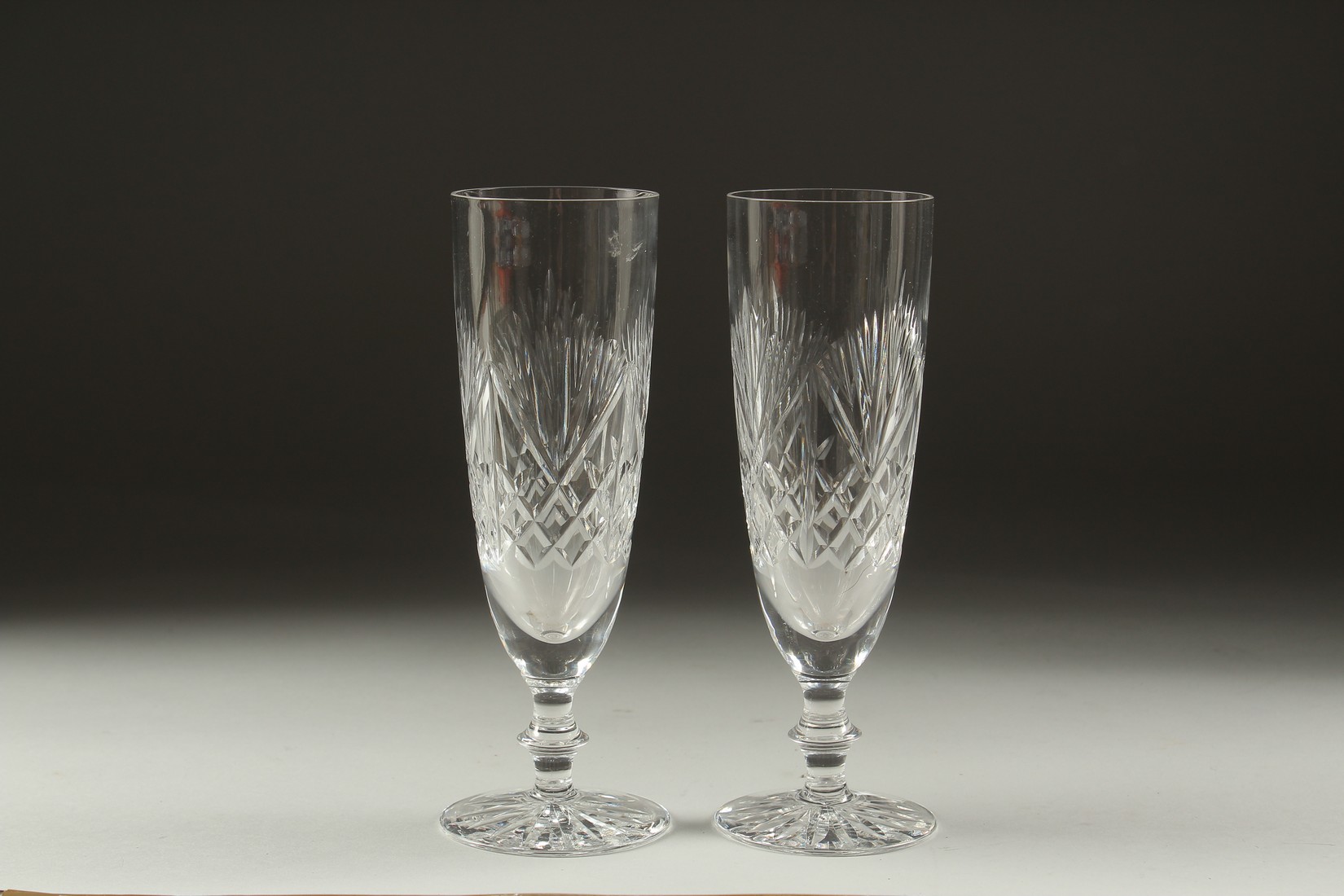 A PAIR OF CUT GLASS WINE FLUTES.