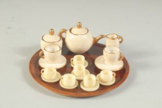 A MINIATURE TEA SET on a circular tray.