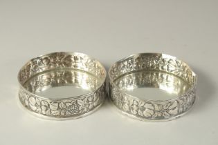 A PAIR OF .800 SILVER FRUITING VINE COASTERS. 4.5ins diameter.