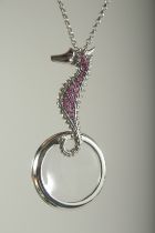 A SILVER RUBY SET SEAHORSE SPYGLASS ON A CHAIN.