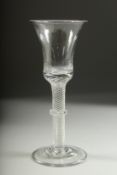A GEORGIAN WINE GLASS with inverted bell bowl, knop stem with air twist. 7ins high.