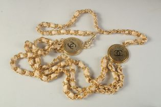 A FOUR ROW CHANEL GILT AND LEATHER BELT with two tags. 64cm long overall.