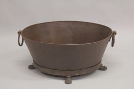A LARGE OVAL CAST IRON PLANTER with ring handles on claw feet. 2ft 3ins diameter.