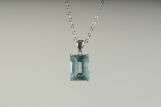 A SILVER EMERALD CUT BLUE TOPAZ PENDANT AND CHAIN, boxed.