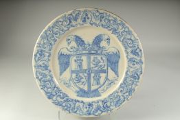 AN ITALIAN MAJOLICA BLUE AND WHITE CIRCULAR CHARGER with a Royal Crest. 17ins diameter.