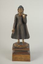 A FINELY FETTLED BRONZE STANDING BUDDHA, fitted to a lotus base plinth, 21cm high.