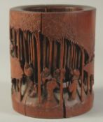 A CHINESE CARVED BAMBOO BRUSH POT, the side carved with a scene of figures amongst bamboo, 14.5cm