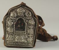 A TIBETAN TRAVELLING BUDDHA SHRINE, with embossed silver depicting lucky symbols, encased with small
