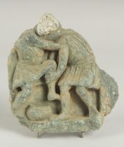 A RARE GANDHARA CARVED STONE TILE FRAGMENT, depicting two men wrestling, 15cm x 14cm.