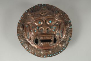 A 19TH CENTURY TIBETAN COPPER INCENSE BURNER WALL MASK, inset with turquoise beads, 24cm diameter.