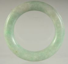 A SMALL ANTIQUE CHINESE JADEITE BANGLE, 6cm diameter.