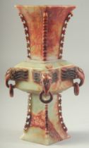 A CHINESE CARVED HARDSTONE VASE, with four drop-rings beneath elephant-like heads, 27.5cm high.