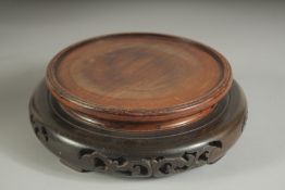A SINGLE CHINESE CARVED HARDWOOD CIRCULAR STAND, with pierced base, the stand to house a base of
