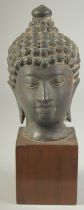 A FINE 19TH CENTURY OR EARLIER THAI BRONZE BUDDHA HEAD, elevated on a wooden base, head 19cm high.