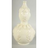 A CHINESE DING STYLE WHITE GLAZED DOUBLE GOURD VASE, with moulded decoration, 29cm high.