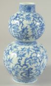 A CHINESE BLUE AND WHITE PORCELAIN DOUBLE GOURD VASE, decorated with peach blossom, 22cm high.