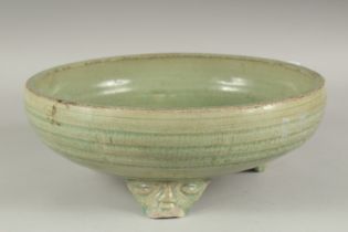 A LARGE CHINESE CELADON GLAZE CIRCULAR CENSER, raised on three moulded legs, 30cm diameter.