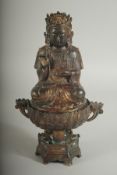 A CHINESE BRONZE SEATED DEITY LIDDED CENSER, the censer of lotus form, with traces of gilt
