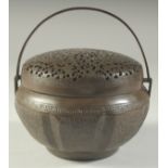 A CHINESE METAL HAND WARMER, with pierced cover, 15cm diameter.