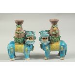 A PAIR OF SANCAI GLAZED POTTERY LION CANDLESTICKS, 16cm high.