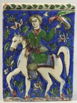 A PERSIAN QAJAR GLAZED POTTERY TILE, with a figure on horseback holding a bird aloft, 22cm x 16cm.