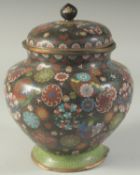 A LARGE JAPANESE BLACK GROUND CLOISONNE JAR AND COVER, with decorative floral roundels, 27cm high.