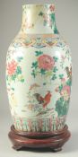A LARGE CHINESE FAMILLE ROSE PORCELAIN VASE, on hardwood stand, painted with cockerels and