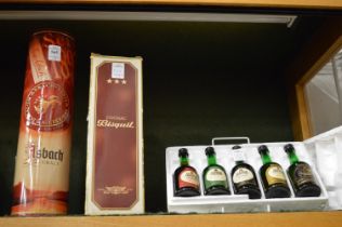 A 1 litre bottle of Asbach Uralt brandy with tin container and another bottle of brandy and a set of