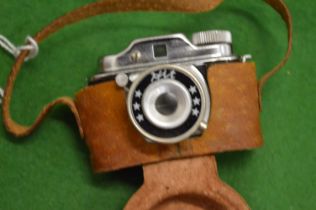 A miniature camera with leather case.