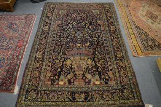 A good Persian part silk rug, dark blue ground with an urn of flowers design, numerous birds and a