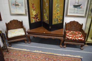 A pair of Chinese carved wood throne style armchairs with matching rectangular table.