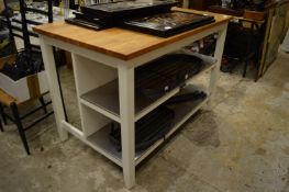 A kitchen work station with hardwood top, the painted base with pair of stainless steel shelves.