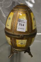 A Continental porcelain and metal mounted egg shaped box with hinged cover.