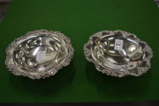A pair of sterling silver pedestal dishes with decorative rims.