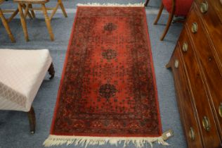 A small Persian design rug, red ground with stylised decoration, 160cm x 83cm.