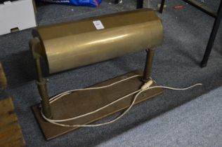 A large brass desk lamp and a brass bound wooden trunk.