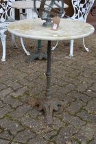 A circular marble patio table with cast iron base.