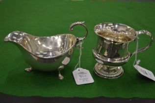 A silver Christening mug and a silver sauce boat.