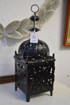 A pair of black painted pierced metal candle lanterns.