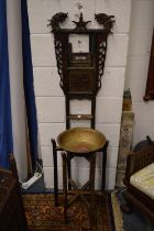 An unusual Chinese washstand with carved and decorated support and brass bowl.
